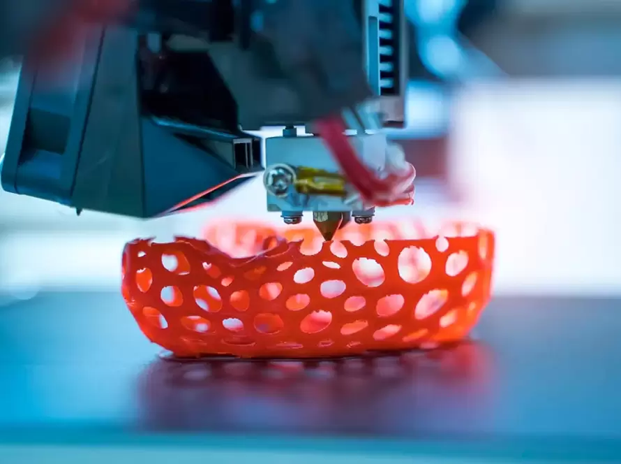 3D spausdintuvas formuoja raudoną grotelių struktūros objektą sluoksnis po sluoksnio